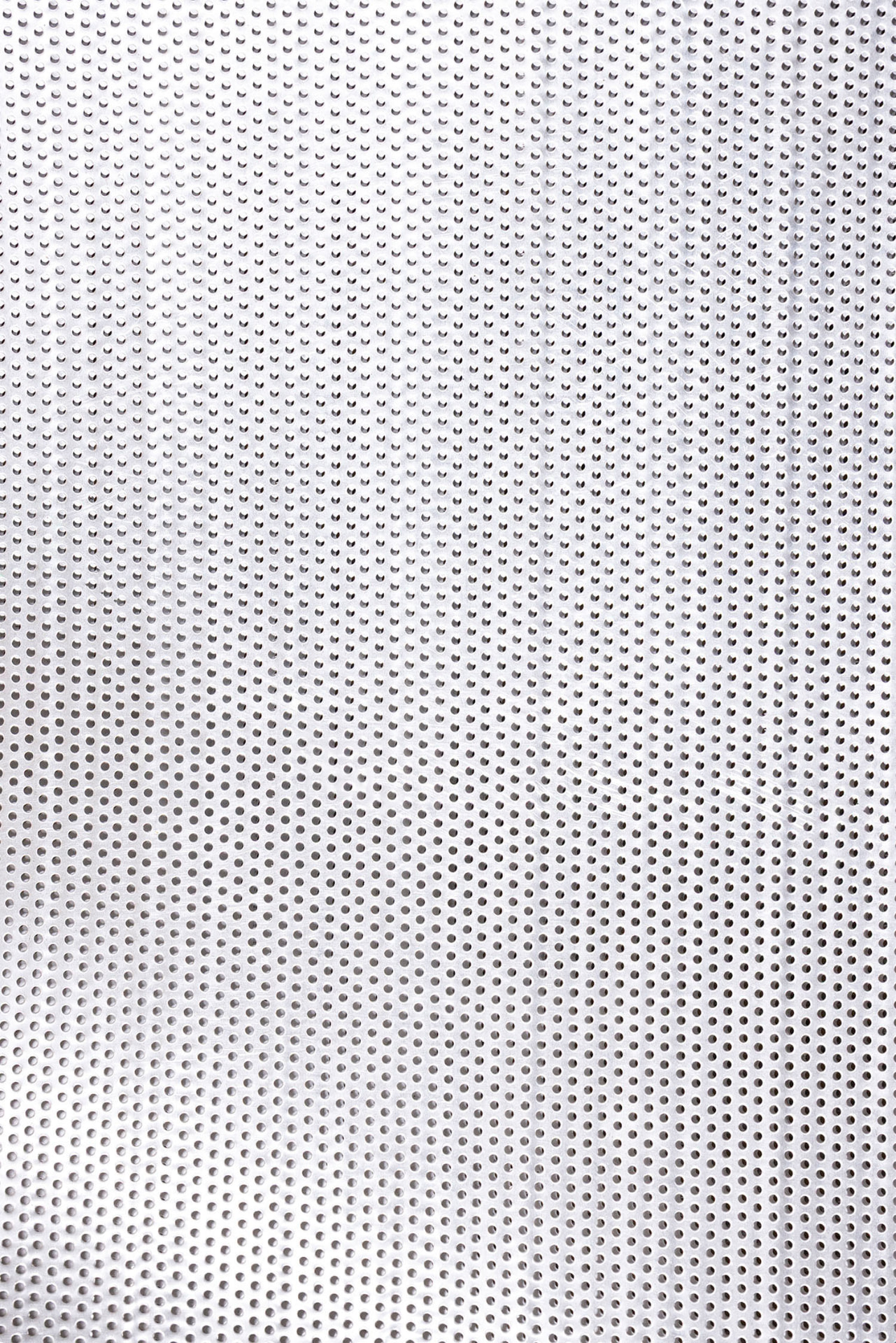 Perforierte helle Metallfläche als rhythmisches Raster