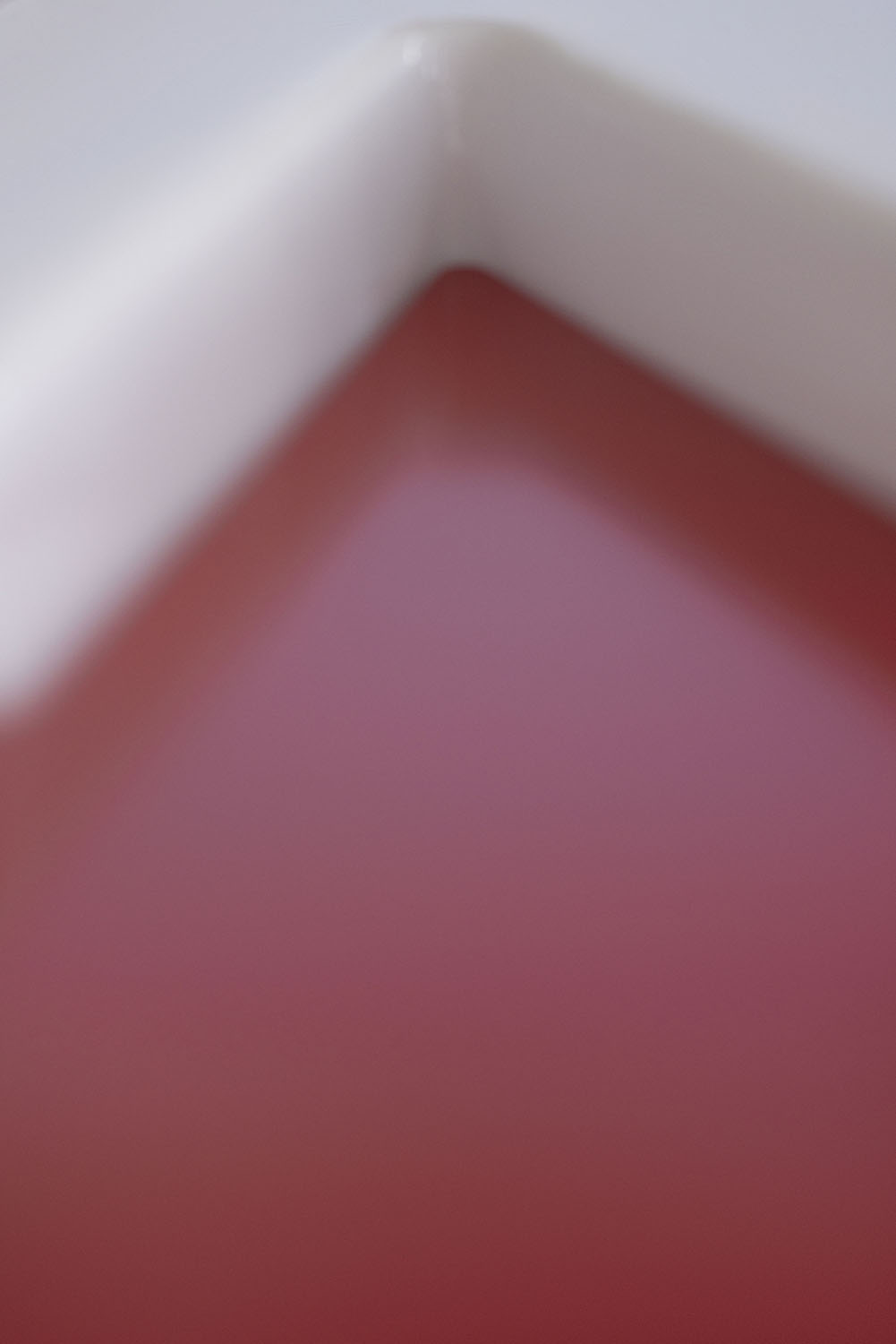 Unscharfe rote geometrische Fläche zwischen hellen Formen