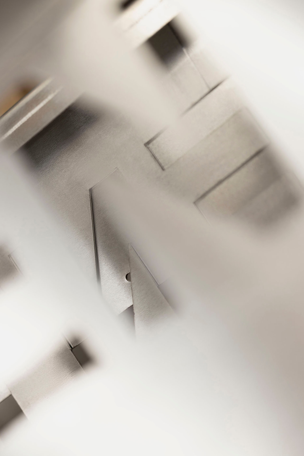 Abstrakte Nahaufnahme gefalteter Metallflächen in weichem Licht