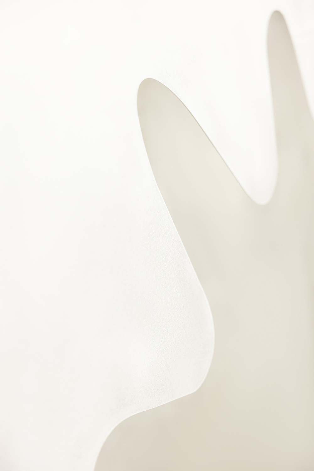 Weiße skulpturale Papierform mit weichen Schatten