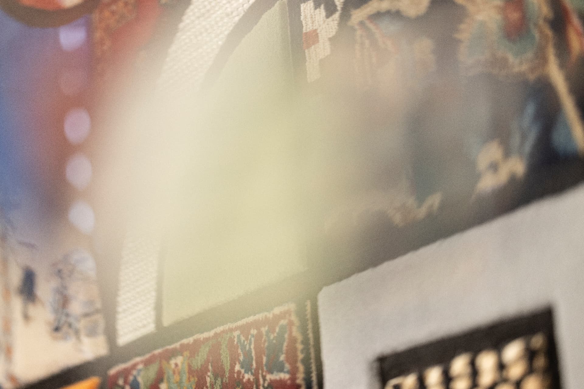 Layered view of textiles and framed works in warm afternoon light