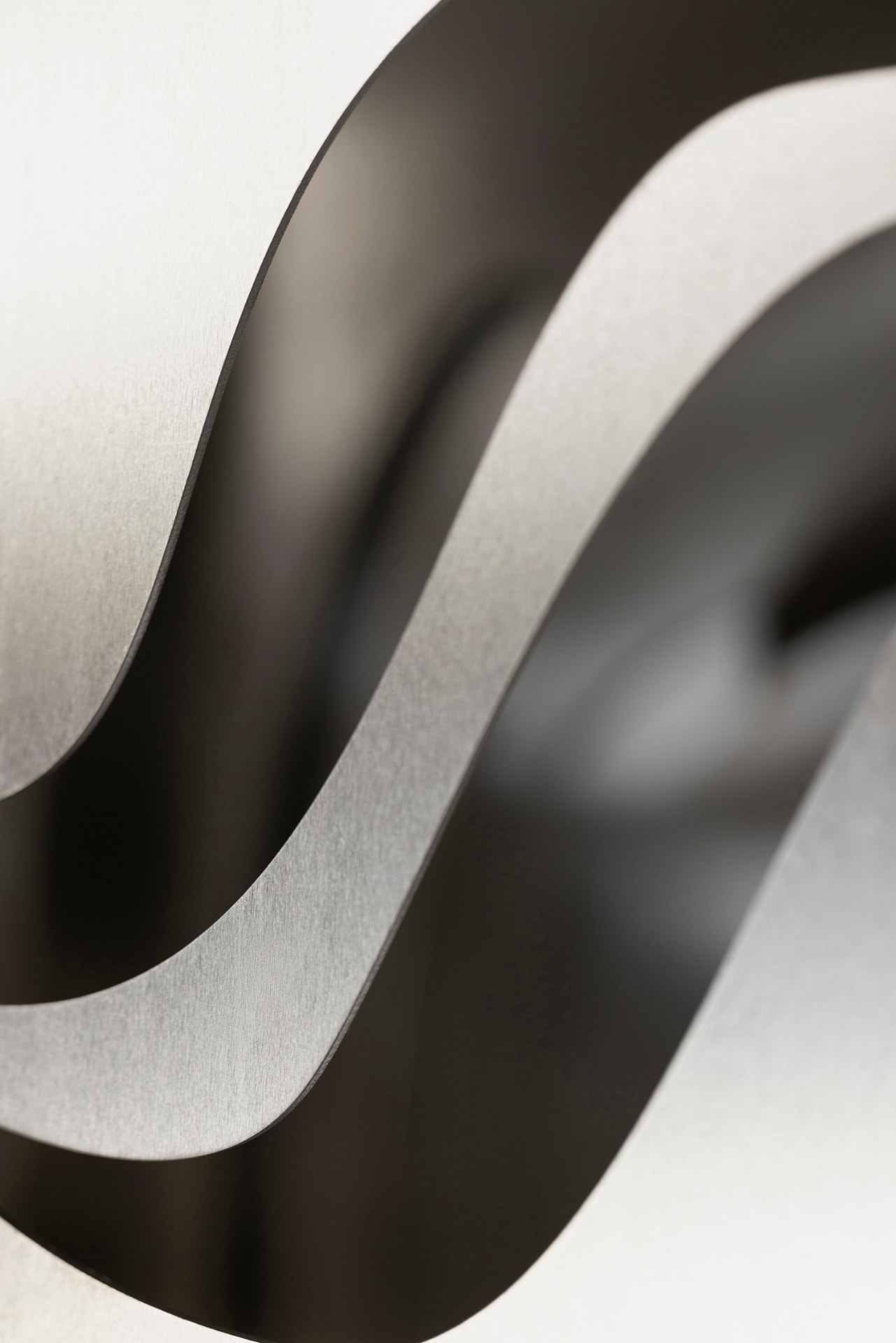 Geschwungene schwarz-silberne Metallbänder im Detail